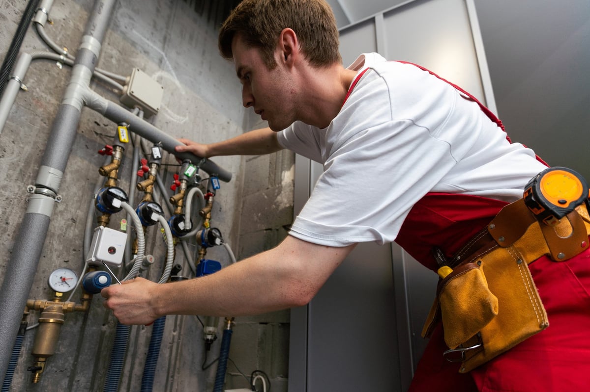 Plumber adjusting a commercial water meter with an adjustable wrench