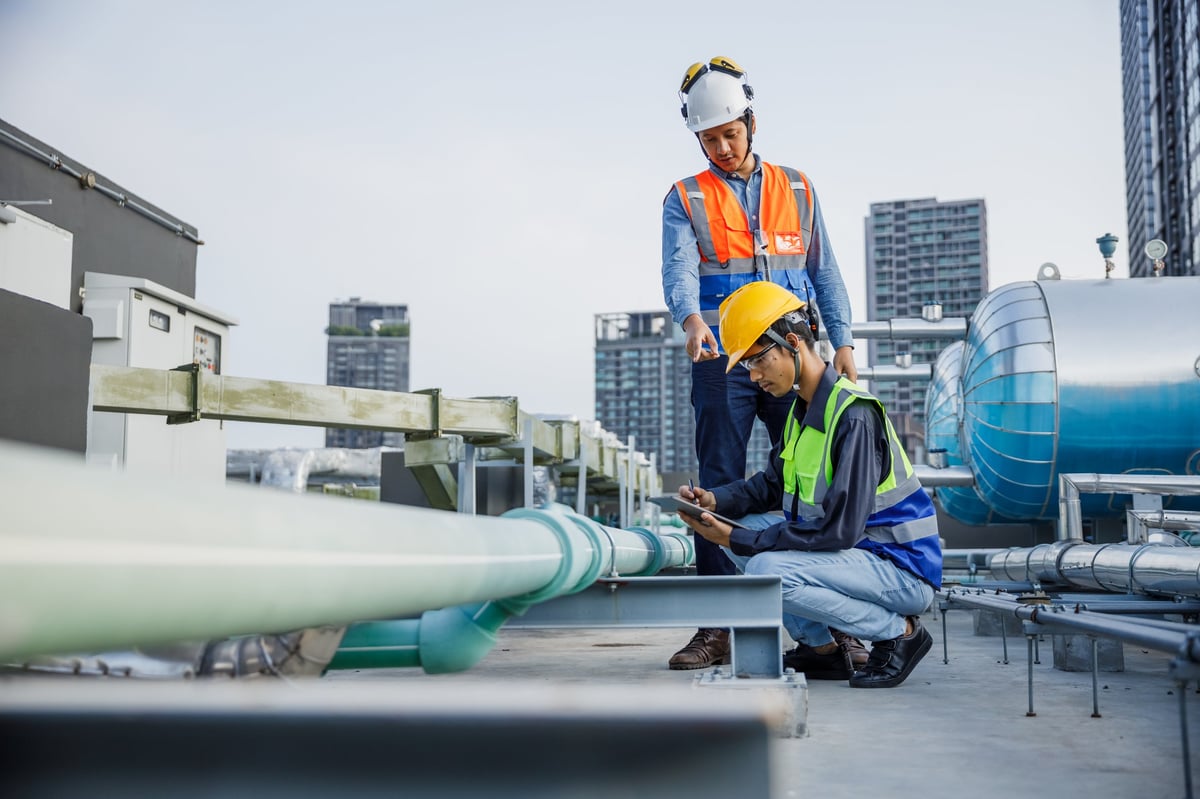 HVAC engineer inspecting a large rooftop commercial air conditioning system