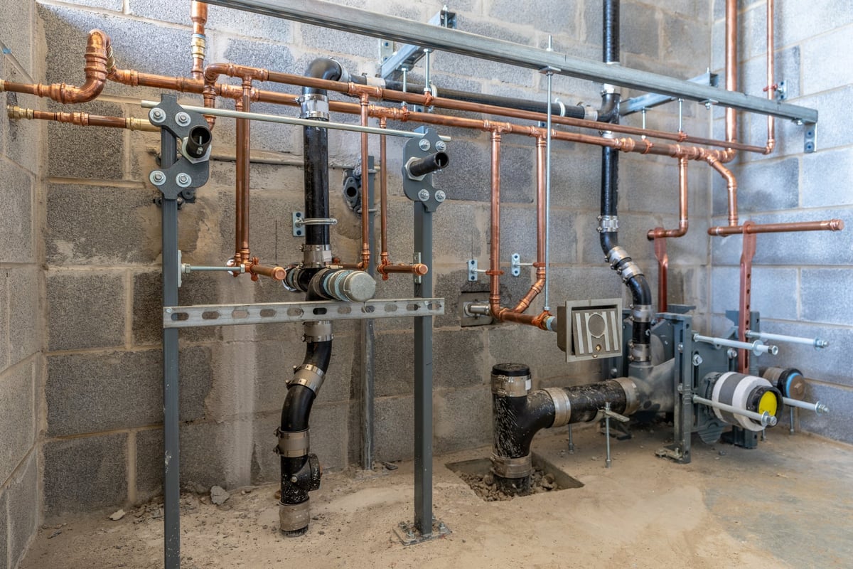 Plumbing rough-in for a new commercial restroom with block wall