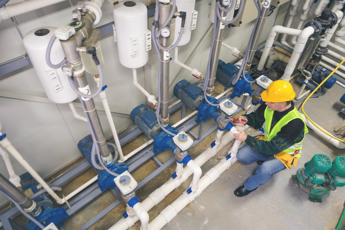 Technician servicing commercial boiler room equipment